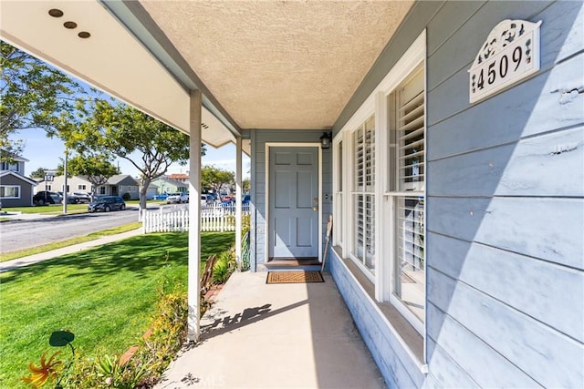 entrance to property featuring a residential view, a yard, and fence