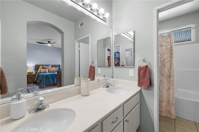 ensuite bathroom with a sink, connected bathroom, double vanity, and tile patterned floors