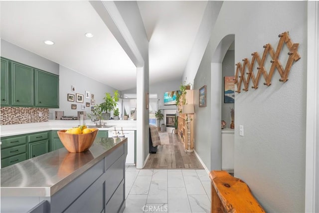 kitchen with stainless steel counters, recessed lighting, a fireplace, marble finish floor, and green cabinetry