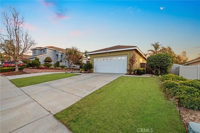 view of front of home with a front yard, fence, an attached garage, stucco siding, and concrete driveway