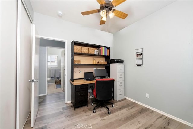 home office featuring light wood-style floors, baseboards, and ceiling fan