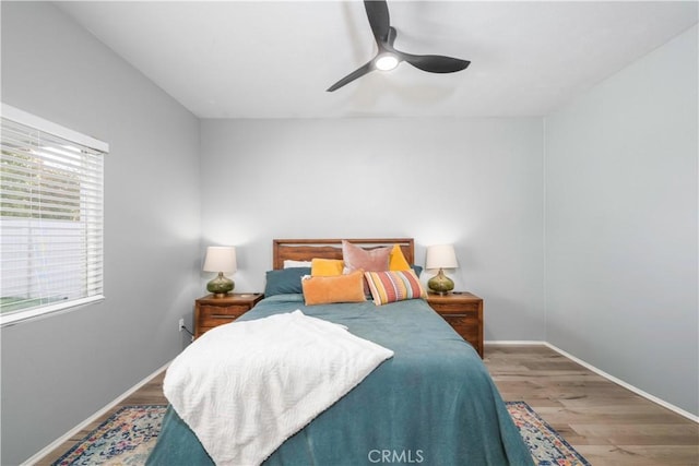 bedroom featuring a ceiling fan, wood finished floors, and baseboards