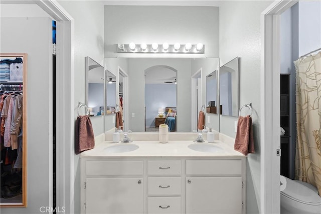 ensuite bathroom with double vanity, toilet, ensuite bath, and a sink