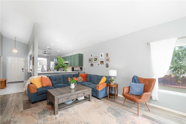 living area with light wood-type flooring, recessed lighting, baseboards, ceiling fan, and vaulted ceiling