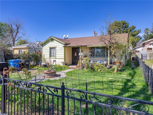 view of front facade featuring fence private yard and a front yard