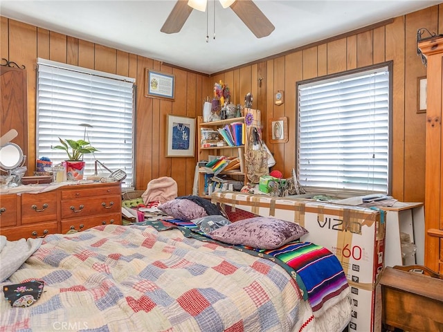 bedroom featuring wooden walls and ceiling fan