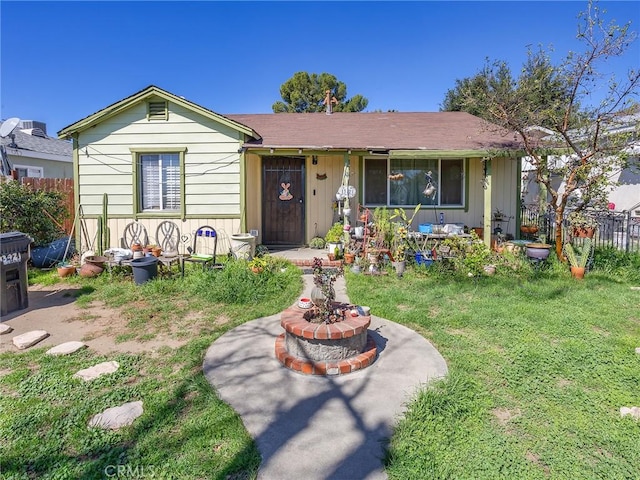 ranch-style home featuring a front lawn and fence