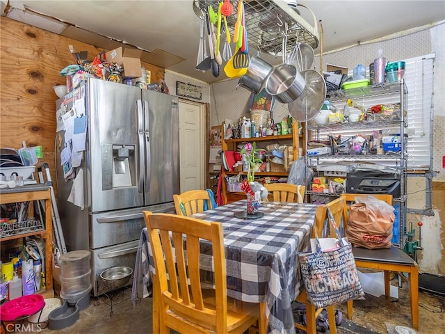 kitchen featuring stainless steel fridge and concrete flooring