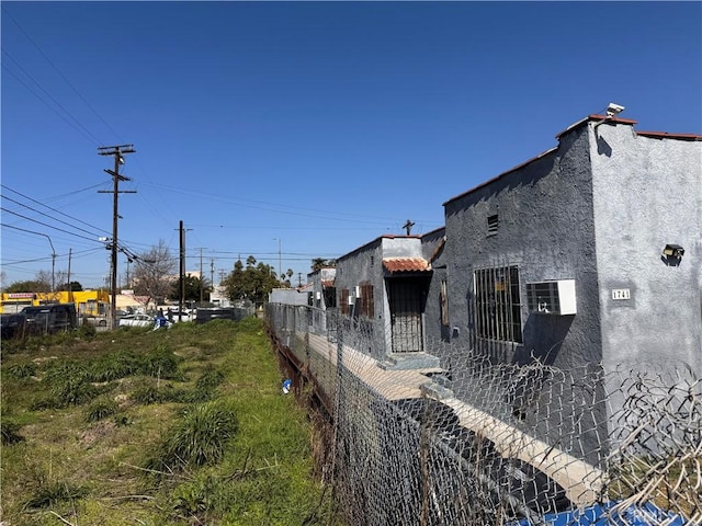 view of home's exterior featuring fence and stucco siding