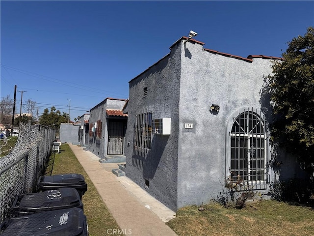 view of home's exterior featuring stucco siding and fence