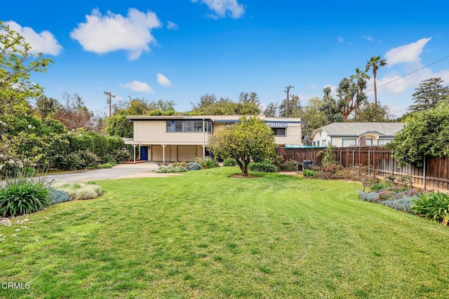 exterior space with a yard, a garage, driveway, and fence