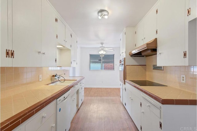 kitchen with oven, under cabinet range hood, a sink, black electric stovetop, and dishwasher