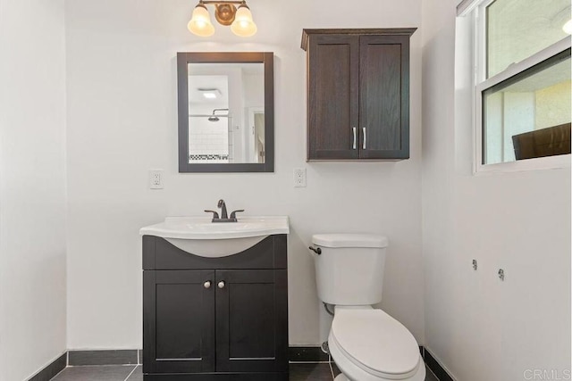 bathroom with baseboards, toilet, and vanity