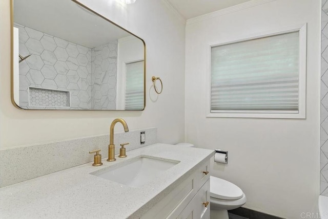 bathroom featuring toilet, vanity, and ornamental molding