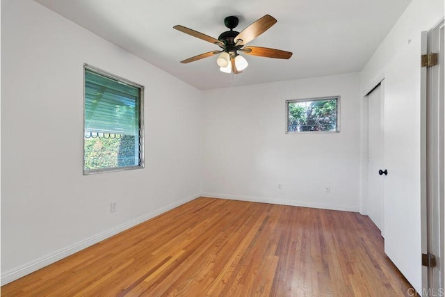 empty room with light wood-type flooring, baseboards, and a healthy amount of sunlight