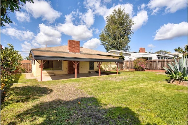 back of house featuring a patio area, a lawn, and a fenced backyard