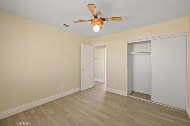 unfurnished bedroom featuring visible vents, a ceiling fan, wood finished floors, a closet, and baseboards