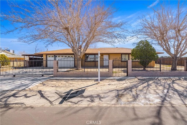 ranch-style house featuring concrete driveway, a gate, and a fenced front yard