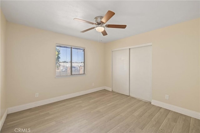 unfurnished bedroom with a ceiling fan, light wood-style flooring, baseboards, and a closet