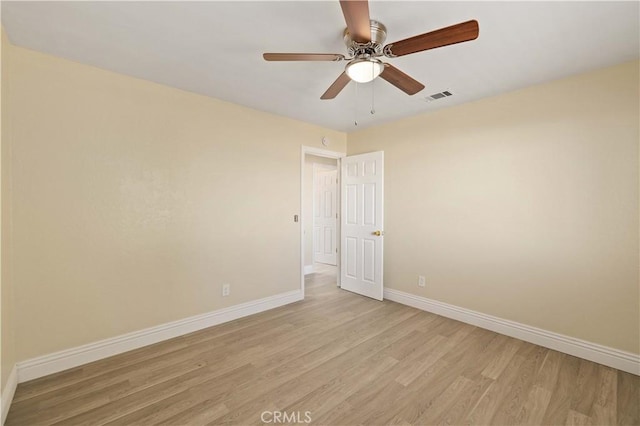 spare room with light wood-type flooring, baseboards, visible vents, and ceiling fan