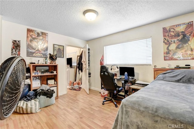 bedroom with a textured ceiling and light wood-type flooring