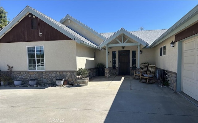 exterior space with stucco siding and stone siding