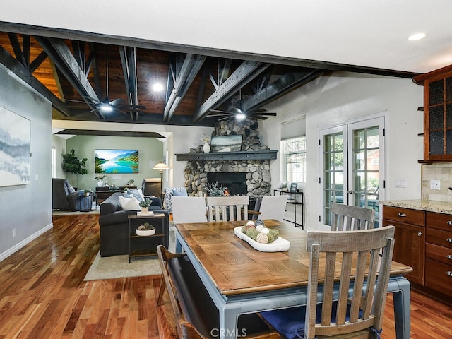 dining space featuring a ceiling fan, dark wood-style floors, baseboards, and a fireplace