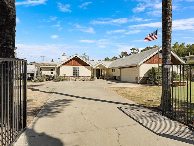 view of front facade with concrete driveway, fence, stone siding, a garage, and a chimney