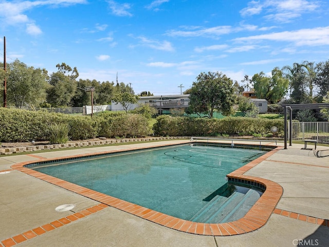 view of swimming pool featuring a patio, fence, and a fenced in pool