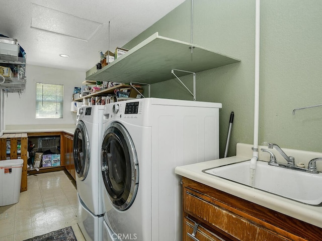 laundry room with washing machine and dryer, a sink, laundry area, and light floors