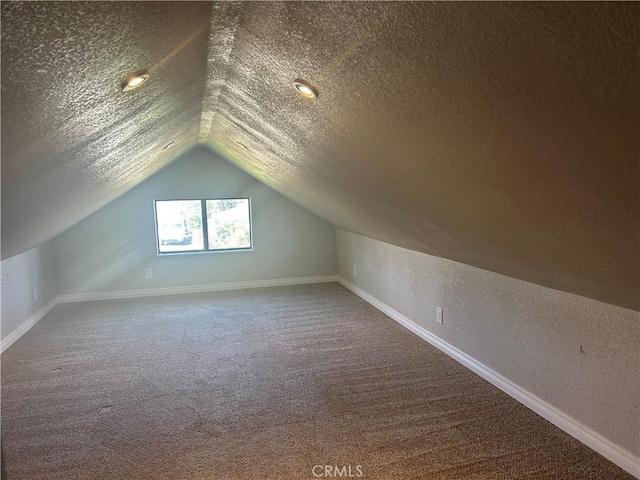bonus room featuring baseboards, lofted ceiling, a textured ceiling, and carpet