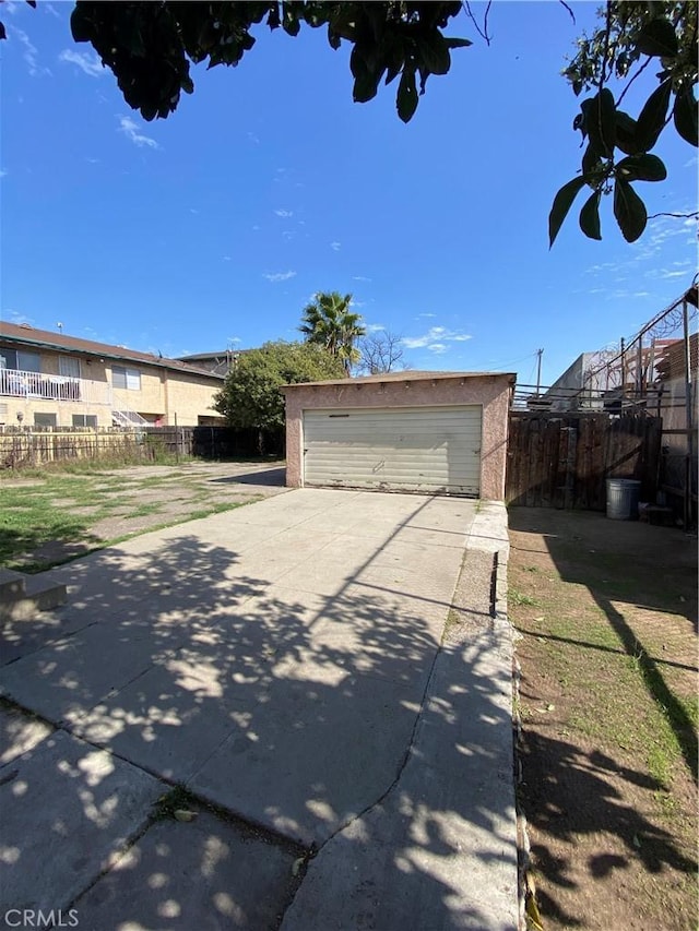 garage featuring fence and driveway