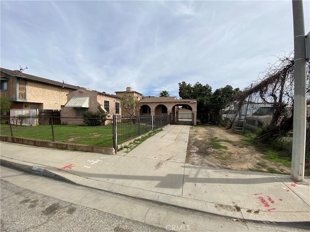 view of front of home with a fenced front yard, a front lawn, and a gate