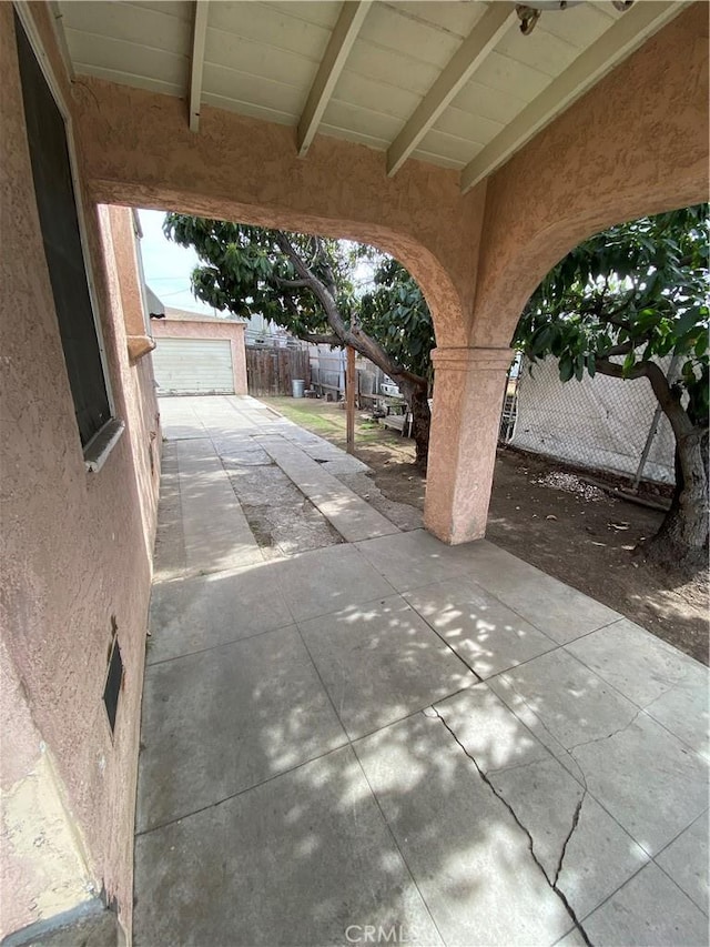 view of patio featuring an outbuilding and fence