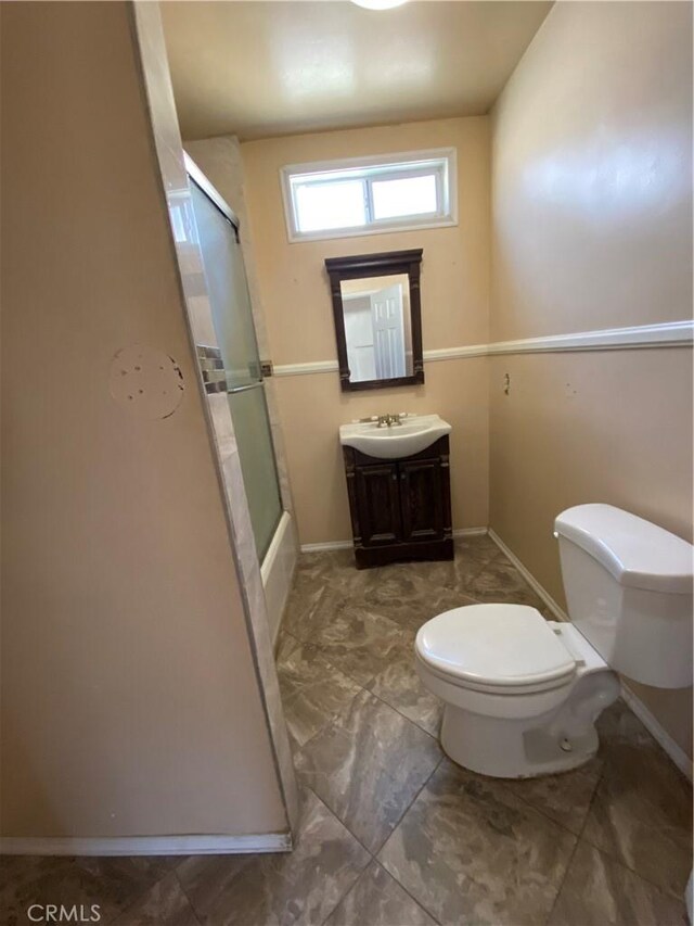 bathroom featuring vanity, toilet, and baseboards