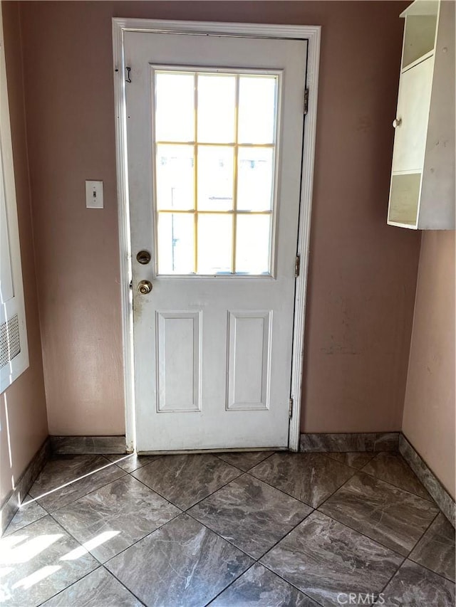 entryway featuring marble finish floor and baseboards