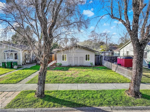 view of front facade with a front lawn and fence