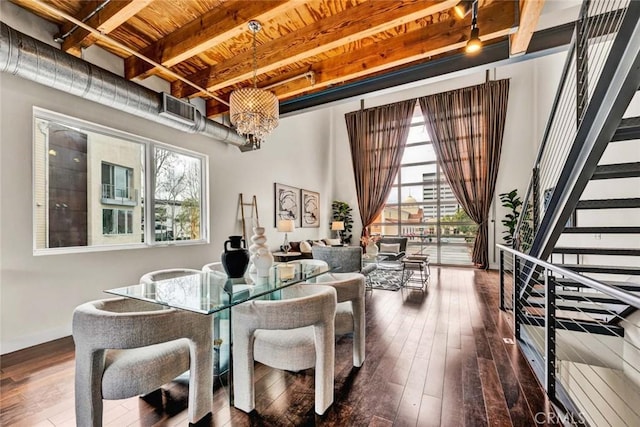 living area featuring beam ceiling, a notable chandelier, a healthy amount of sunlight, and hardwood / wood-style floors