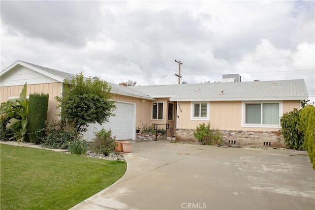 single story home featuring brick siding, an attached garage, concrete driveway, and a front lawn