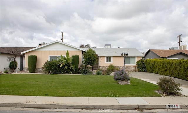 ranch-style house with a front lawn and stone siding