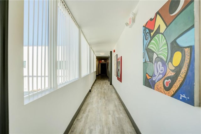 hallway featuring baseboards and wood finished floors