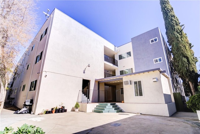 rear view of property with stucco siding and visible vents