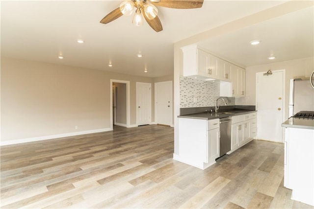 kitchen with light wood-style flooring, stainless steel dishwasher, freestanding refrigerator, white cabinets, and a sink