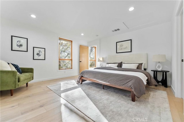 bedroom with light wood finished floors, visible vents, recessed lighting, and attic access