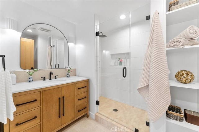 bathroom featuring tile patterned floors, visible vents, a shower stall, and vanity