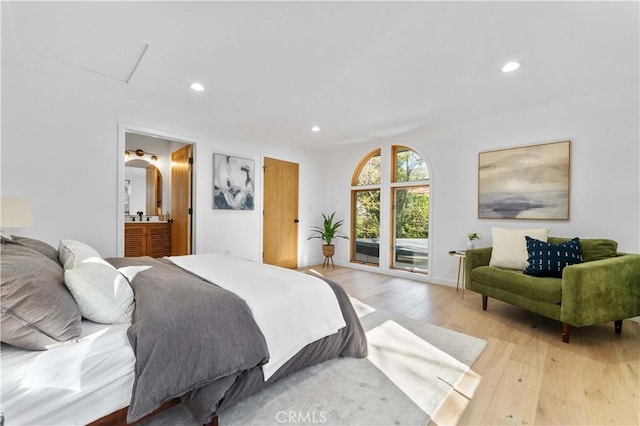 bedroom with ensuite bath, recessed lighting, arched walkways, access to exterior, and light wood-type flooring