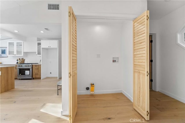 laundry area featuring light wood finished floors, baseboards, washer hookup, laundry area, and recessed lighting