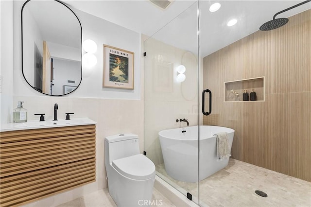 full bath featuring walk in shower, toilet, vanity, a soaking tub, and tile walls