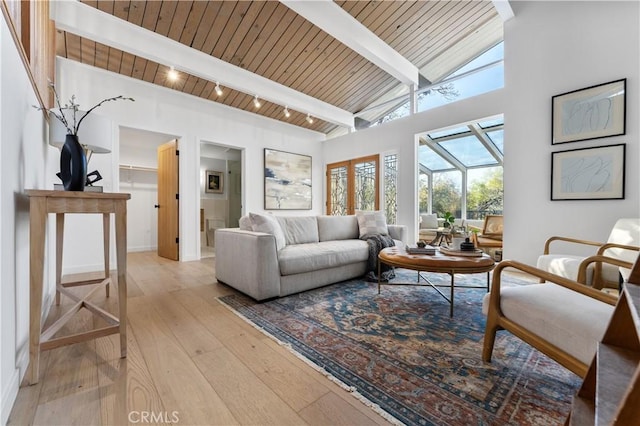 living area featuring hardwood / wood-style floors, high vaulted ceiling, beam ceiling, a sunroom, and wood ceiling