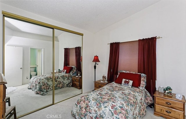 bedroom featuring vaulted ceiling, a closet, carpet floors, and a textured ceiling